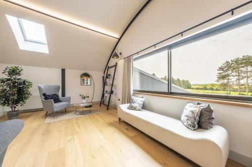 a living room with a couch and a large window at Fitters Barn in Warham