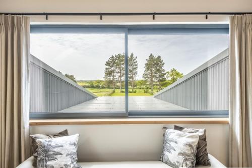 a room with a large window with a view of a boardwalk at Fitters Barn in Warham