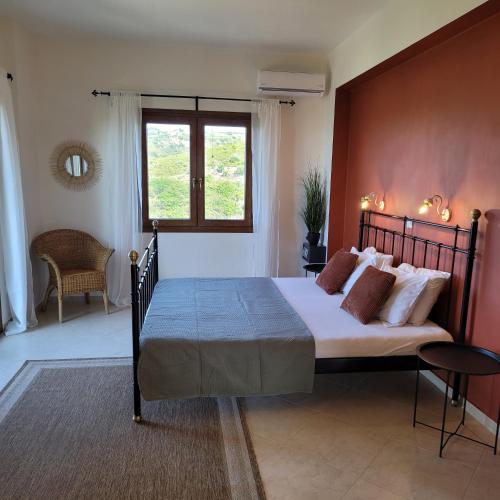 a bedroom with a large bed and a window at Villa Farangi in Gállos