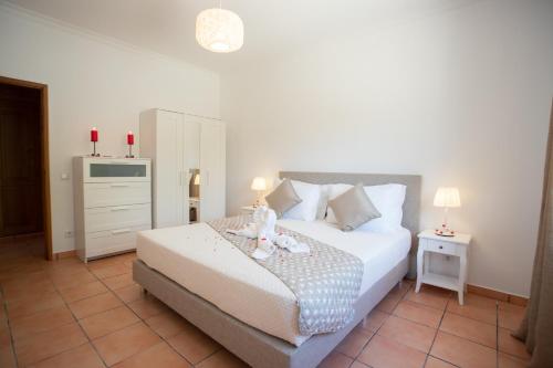 ein Schlafzimmer mit einem Bett mit zwei Kerzen darauf in der Unterkunft VILLA CARACOL Heated Swim Spa & Mini-Golf in Luz de Tavira