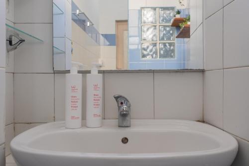 un lavabo con dos botellas blancas encima en Vintage Apartment in Lingotto Area by Wonderful Italy, en Turín