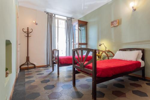 1 dormitorio con 2 camas y manta roja en Vintage Apartment in Lingotto Area by Wonderful Italy, en Turín