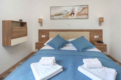 a bedroom with a blue bed with towels on it at Villa Kaoru brand new Villa with a heated swimming pool in Malinska