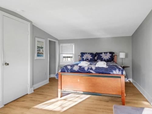 a bedroom with a bed with a blue comforter at The Thistle Inn in Boothbay Harbor