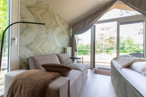 a living room with a couch and a large window at Boetiekpark 't Zwaantje in Mook