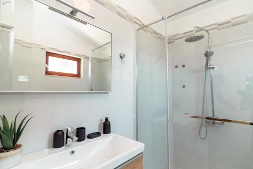 a bathroom with a shower and a sink and a mirror at Sea View House & Free Parking in Podstrana
