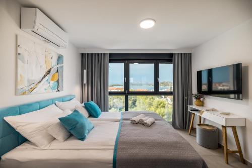 a bedroom with a large bed with a desk and a window at Villa Burin in Murter