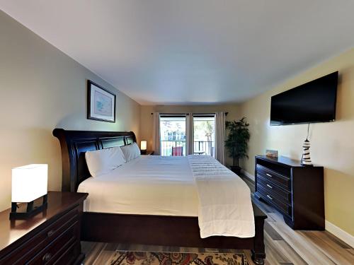 1 dormitorio con 1 cama grande y TV de pantalla plana en Edgewater Villa 2112, en Panama City Beach