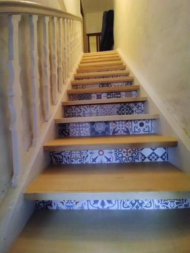un escalier dans une maison revêtue de carrelage bleu et blanc dans l'établissement Charmante chambre dans village jurassien, à Nogna