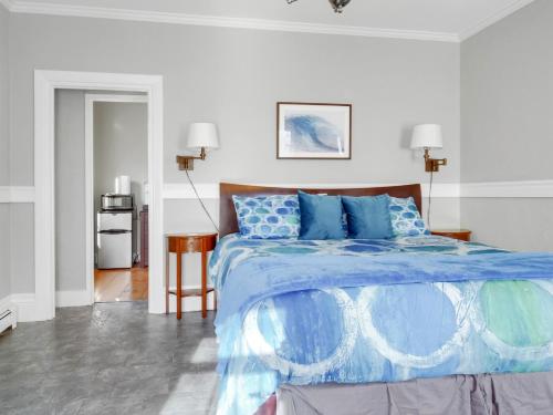 a bedroom with a large bed with blue sheets at The Thistle Inn in Boothbay Harbor