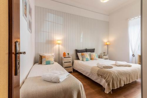 2 Betten in einem Zimmer mit weißen Wänden in der Unterkunft ALM- Spacious. Sunny. Patio. Quiet area. FAST WIFI in Lissabon