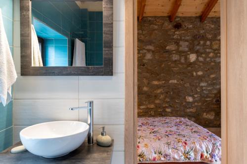 Eftichia's Nomad stone house : حمام مع حوض استحمام ومغسلة