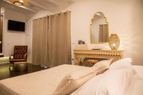 a bedroom with a bed and a mirror and a fireplace at Amelia Apts & Rooms in Alghero