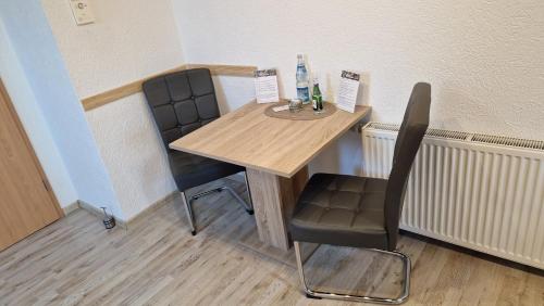 a wooden table and two chairs in a room at AMW Ferienwohnungen in Legau