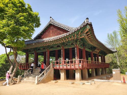 a large wooden building with people walking around it at Jahayeon Hanokstay in Jeonju