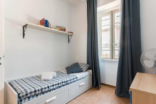 a small bedroom with a bed and a window at Home Romana Centro Nettuno in Nettuno