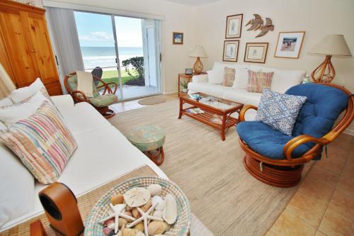 ein Wohnzimmer mit einem Sofa, Stühlen und Meerblick in der Unterkunft Colony Beach Club 128 in New Smyrna Beach