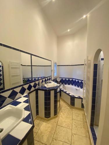 a bathroom with two sinks and a tub and a toilet at Villa du Soleil en Provence sur le Domaine du Golf de Pont Royal in Mallemort