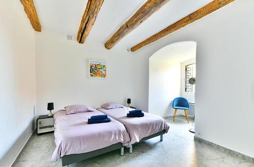 une chambre avec un grand lit dans une pièce blanche dans l'établissement Bel appartement dans les remparts à 50 m de la mer, à Antibes