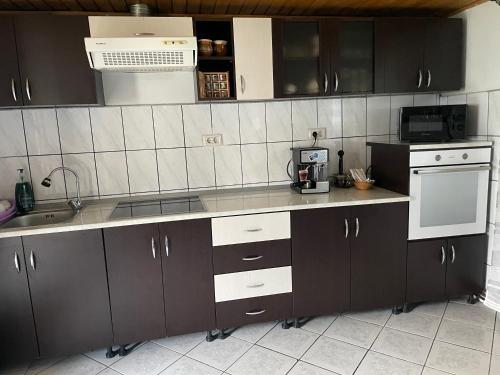 una cocina con armarios negros y un aparato blanco en Casa Ella Maldaresti en Măldăreşti