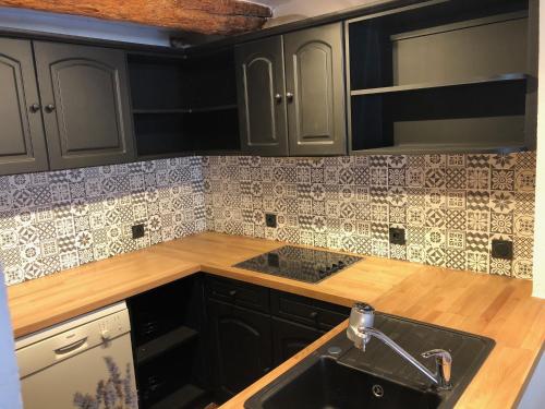 - une cuisine avec des placards noirs et un évier dans l'établissement Bel appartement dans les remparts à 50 m de la mer, à Antibes