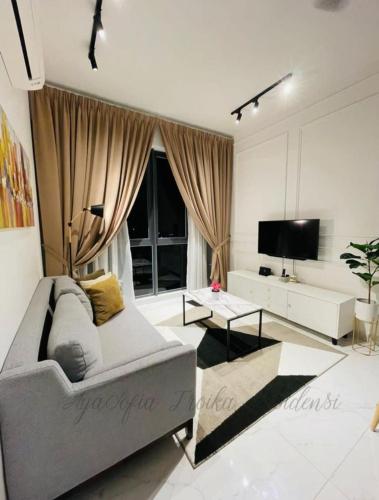 a living room with a couch and a tv at AYASOFIA TROIKA CITY VIEW ( Wifi, Netflix, 4-6 pax) in Kota Bharu