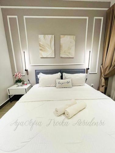 - une chambre avec un grand lit blanc et 2 serviettes dans l'établissement AYASOFIA TROIKA CITY VIEW ( Wifi, Netflix, 4-6 pax), à Kota Bharu