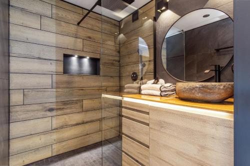 une salle de bain avec un lavabo et un miroir dans l'établissement Unik Heliopolis naturiste, au Cap d'Agde