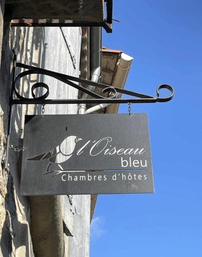 a sign on the side of a building with a bird on it at L'Oiseau Bleu PEACOCK in Roubia