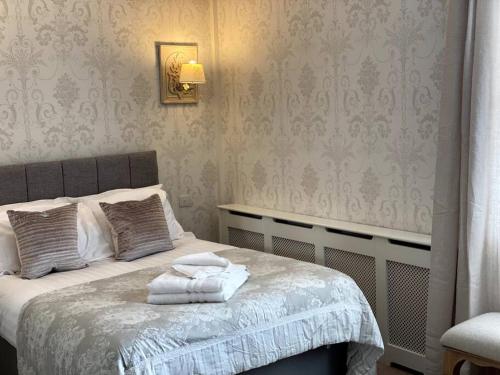 a bedroom with a bed with towels on it at Dovecote Cottage. in Newcastle upon Tyne