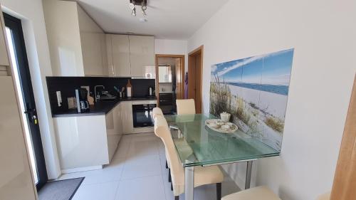 a kitchen with a glass table and chairs in it at Villa unter dem Schloss in Cleebronn