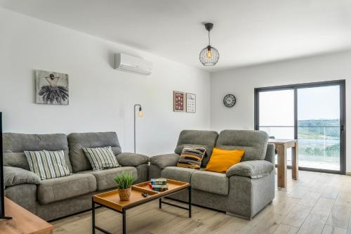 a living room with two couches and a table at Apartamento Campo e praia in Aljezur
