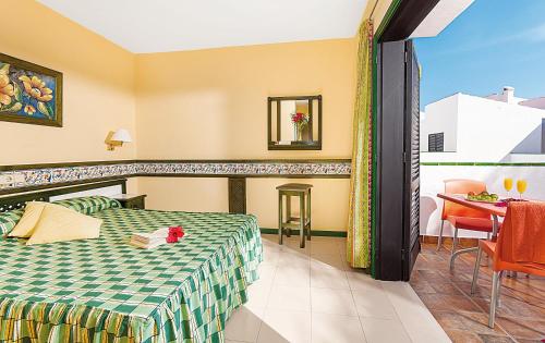Habitación de hotel con cama y balcón en Puerto Caleta en Caleta de Fuste