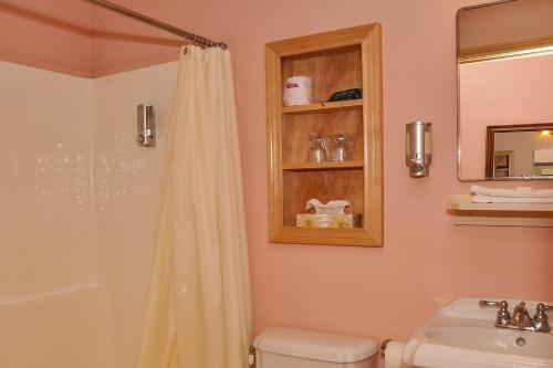 a bathroom with a shower and a toilet and a sink at Chanterelle Inn & cottages in Baddeck