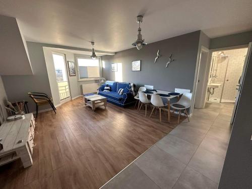 sala de estar con sofá azul y mesa en Apartament Albatros en Darłowo