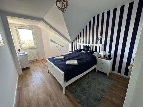 a bedroom with a bed with a blue comforter at Apartament Albatros in Darlowko