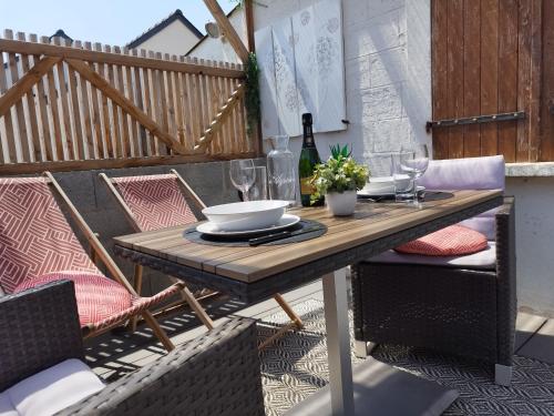 un tavolo e sedie in legno su un patio di L'Intimiste Balnéo Spa, pure détente et romantisme a La Richardais