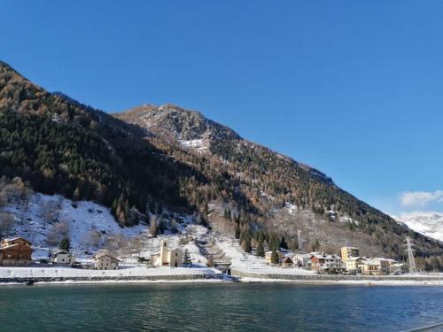 a town on the shore of a lake with a mountain at Appartamento sul Liro in Campodolcino