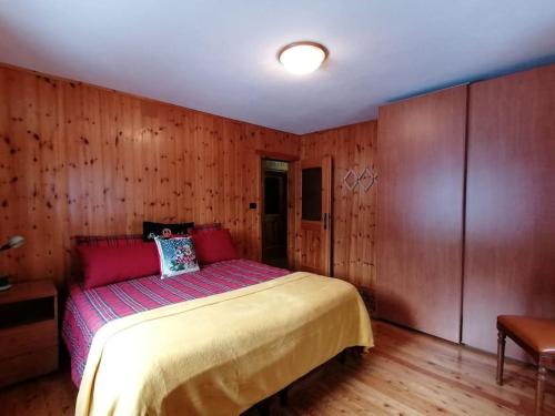 1 dormitorio con 1 cama en una habitación con paredes de madera en Appartamento sul Liro, en Campodolcino