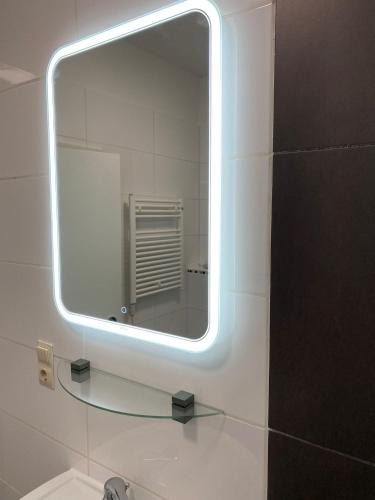 a mirror in a bathroom with a sink and a mirror at Am Bahnhof in Bersenbrück