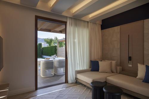 a living room with a couch and a sliding glass door at Atlantica Holiday Village Rhodes in Kolymbia