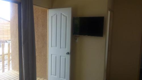 uma porta com uma televisão de ecrã plano na parede em Alojamiento Portofino Chañaral. em Ciudad de Chañaral
