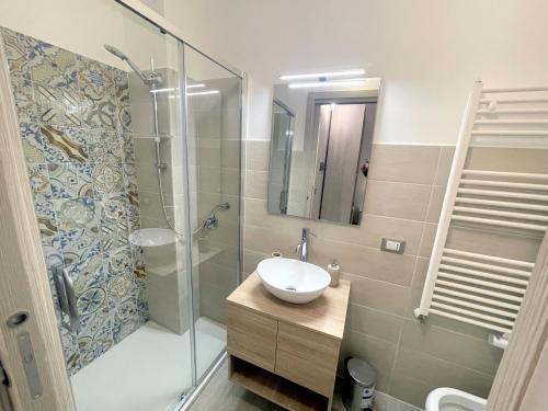 a bathroom with a sink and a glass shower at I MORI - Holiday Rooms in Lascari