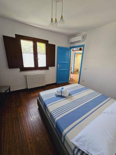 a bedroom with a large bed with blue and white sheets at Casa Vacanze L'Ulivo di Ugo in Quartu SantʼElena