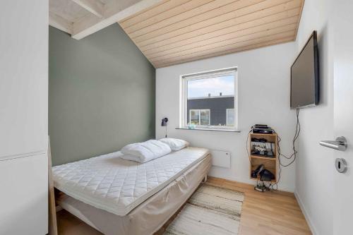 a bedroom with a bed and a flat screen tv at Stokholms Sommerhus in Skals