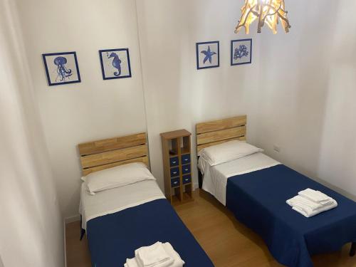 - une chambre avec 2 lits et un lustre dans l'établissement IL FARO in centro vicino Pompei Amalfi Sorrento, à Castellammare di Stabia