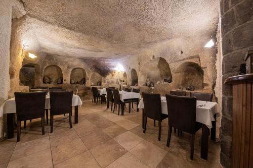 於爾居普的住宿－Konak Bezirhane Cave Otel，大楼内带桌椅的用餐室