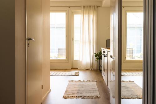 a hallway with a door open to a room with windows at Ihastuttava luhtitaloyksiö in Kokkola