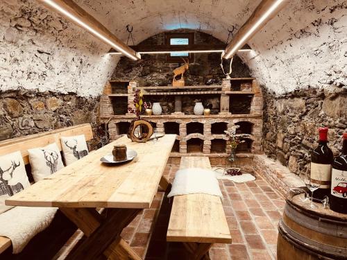 a room with a wooden table and some bottles of wine at Chalet Wolfbachgut in Taxenbach