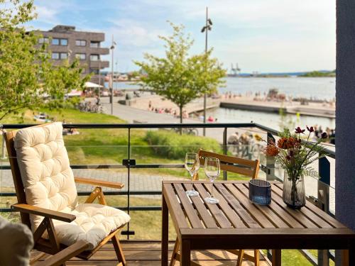 a wooden table and chairs on a balcony with a view of the water at Beachfront apartment Sørenga Oslo in Oslo